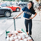 A student pulls a cart full of bread