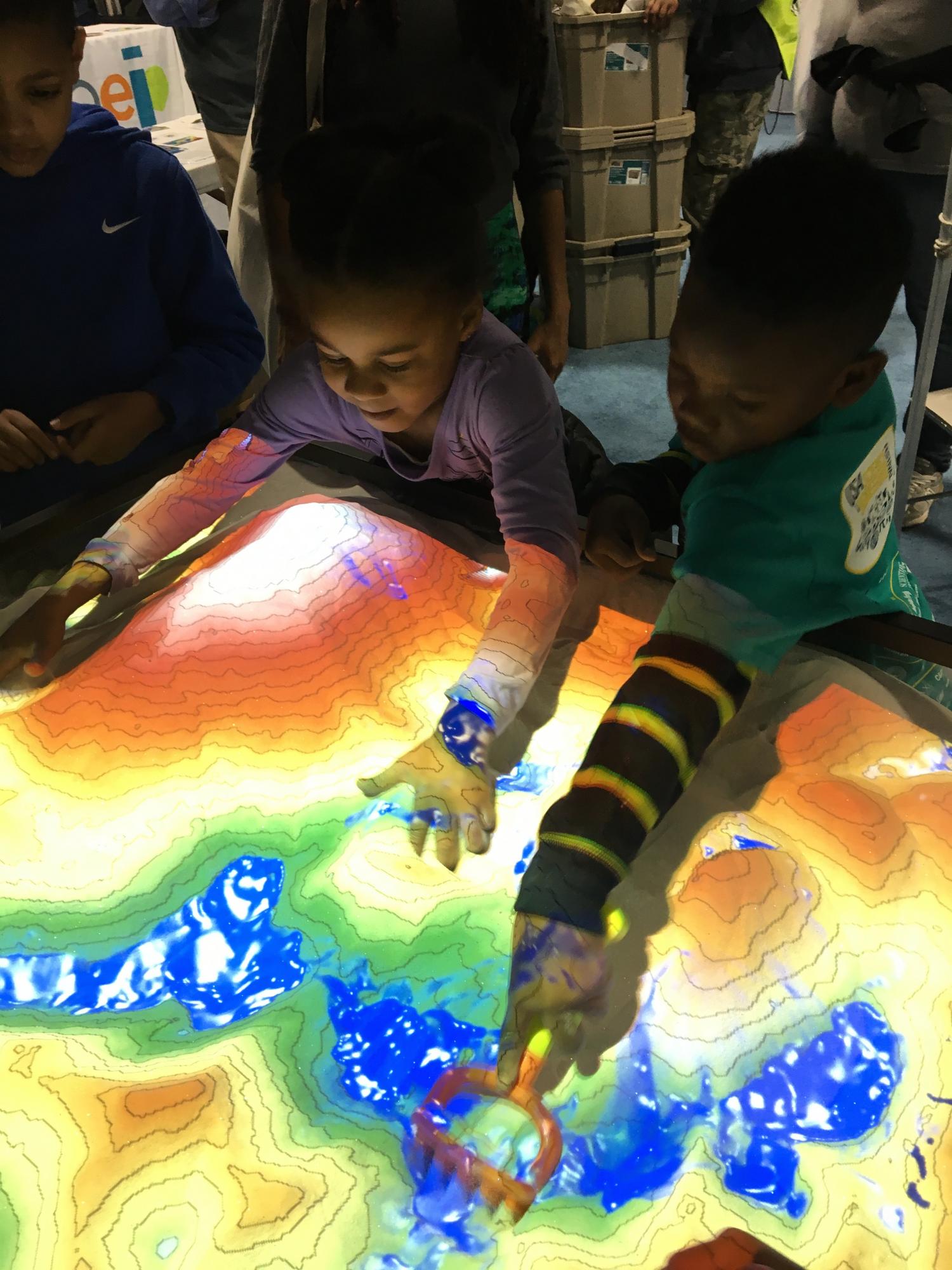 Kids play with Augmented Reality sandbox