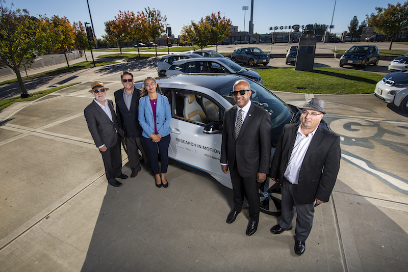 Transportation Researchers in front of an electric vehicle at UC Davis