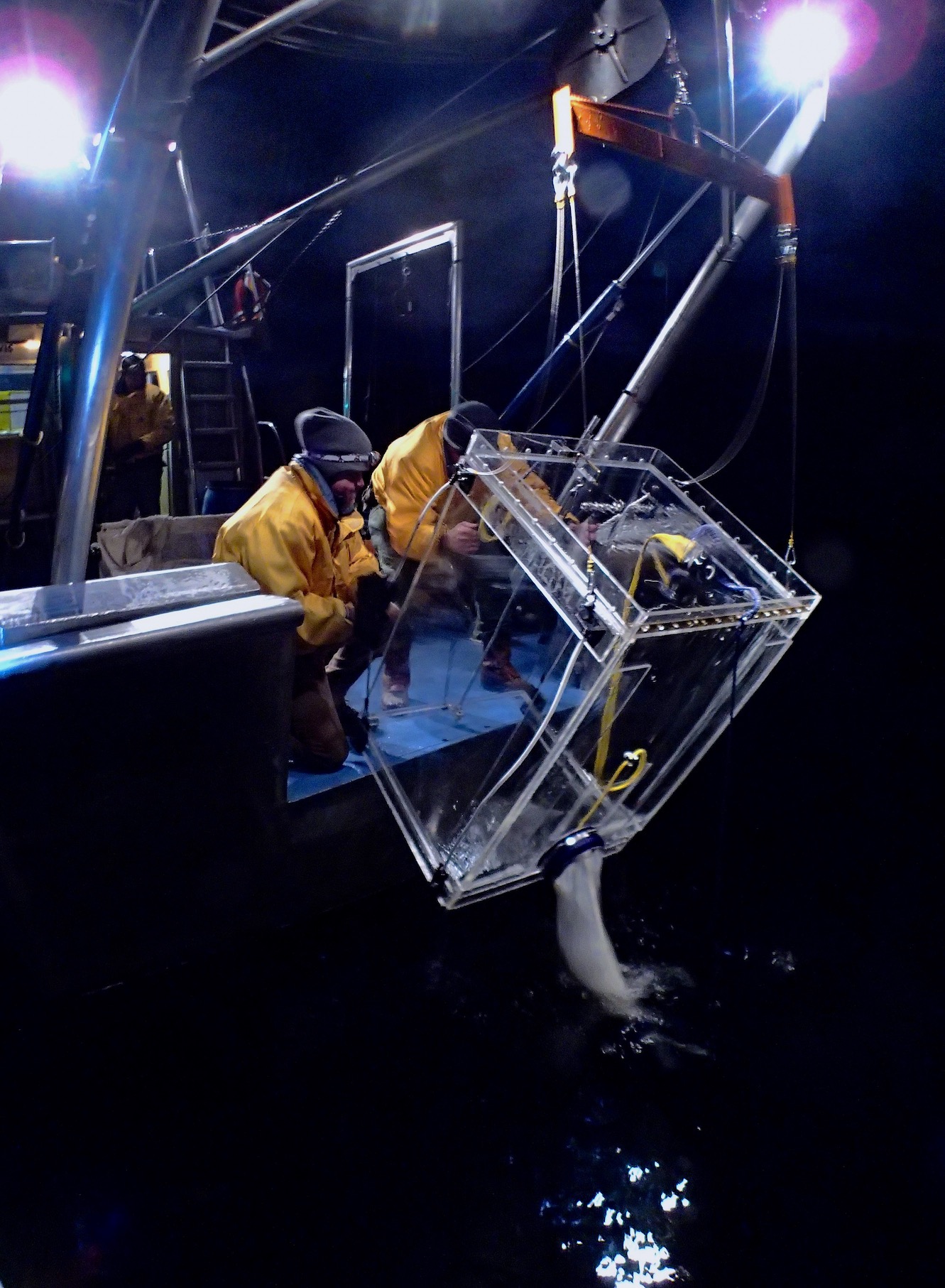 Two scientists bring in cage while trawling for mysis shrimp at night at Lake Tahoe