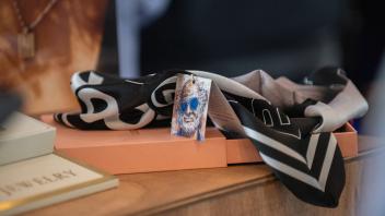 Alt-Tag: A silk Bookhead scarf is displayed with a tag showing a drawing of Robert Arneson.