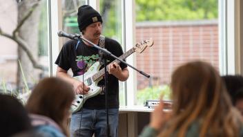 A guitarist plays in front of an audience of UC Davis students at the Memorial Union.