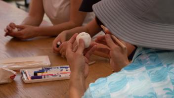 A student molds an Egghead out of clay at a Manetti Shrem Picnic Day event.