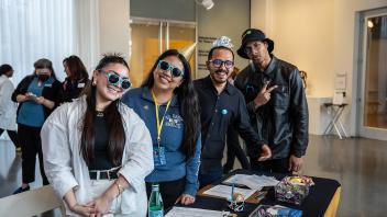 Four Strategic Communications staff members smile happily at the camera during the Year of the Eggheads VIP celebration.