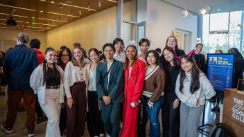 A large group of Strategic Communications staff members smile happily at the camera during the Year of the Eggheads VIP celebration.