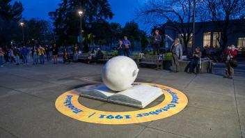 The Bookhead is lit from above at dusk and encircled by a large yellow sticker commemorating its 30th anniversary.