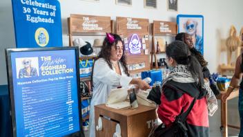 A cashier assists a woman with her purchase at the Manetti Shrem Museum Collection Pop-Up Shop.