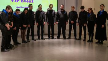 The UC Davis Concert Choir stands in a semi-circle before they perform at the Year of the Eggheads VIP celebration.