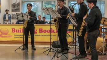 A group of four musicians with brass instruments perform in Shields Library for the Year of the Eggheads VIP celebration.