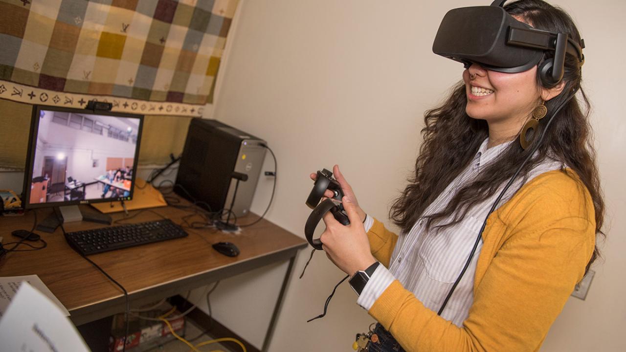 Communications graduate student Gracie Wolff wears a virtual reality headset to study the effects of role playing on public pers
