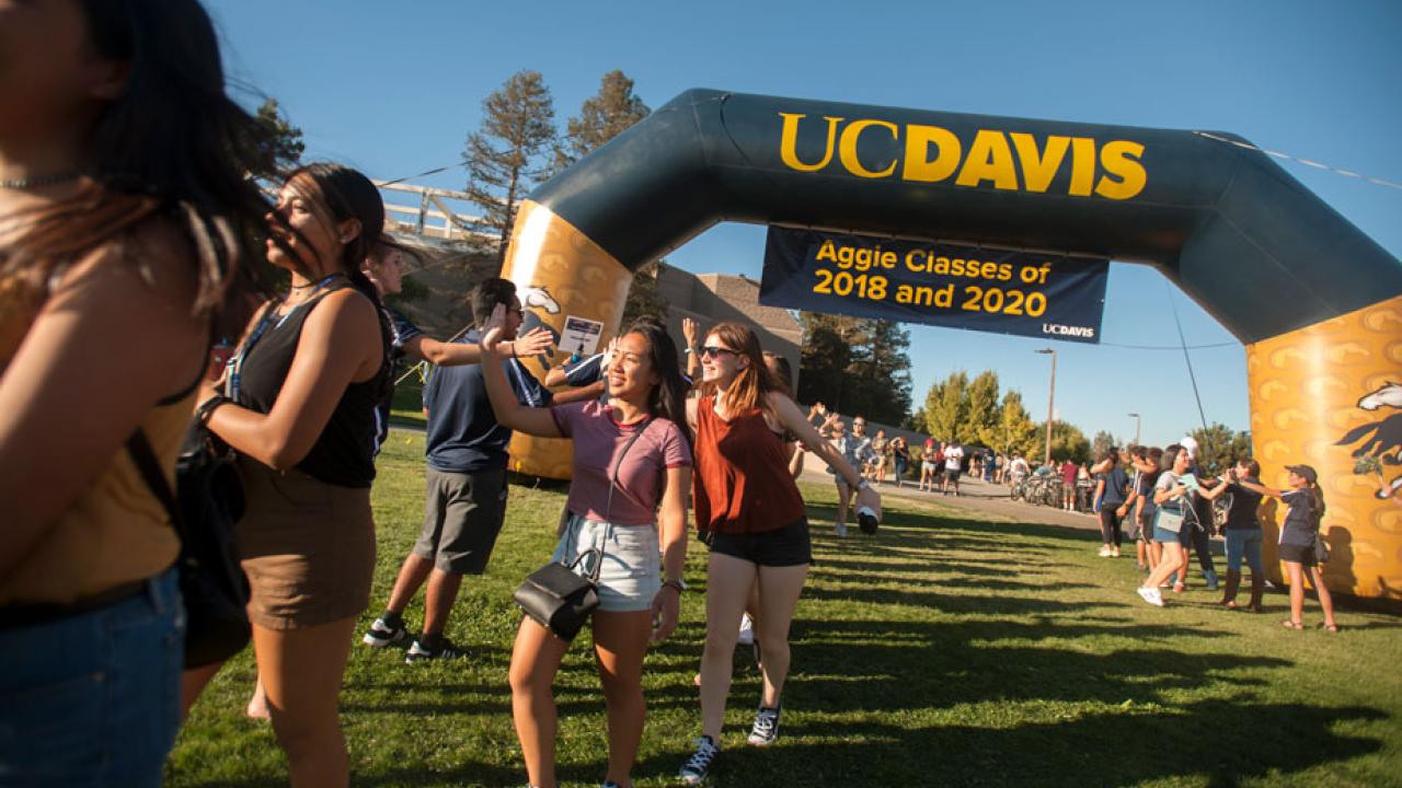 Students run under the New Student balloon arch, 2016.