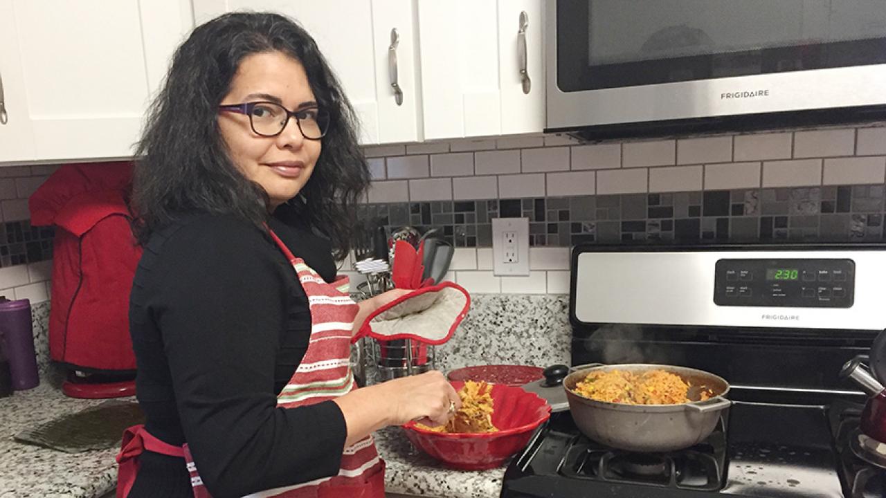 Assistant Professor Lilian Cruz-Orengo cooking looks forward to sharing traditional Puerto Rican flavors with e