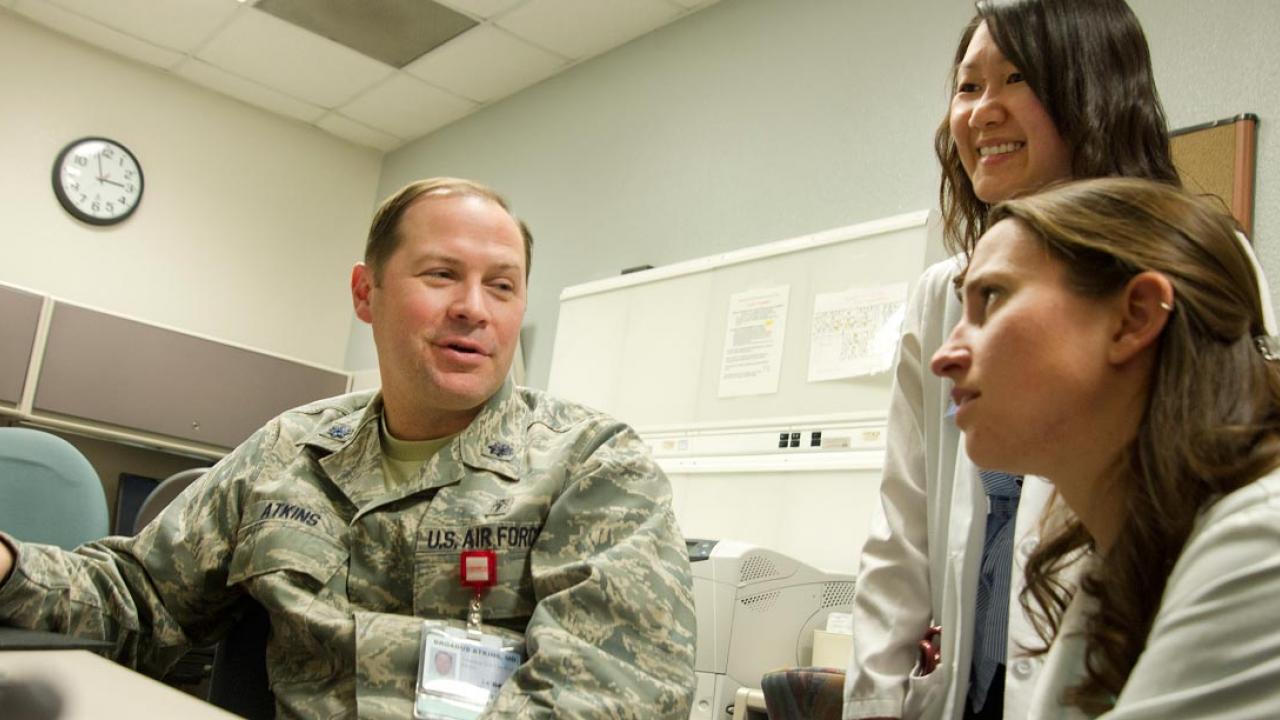 Doctor in Army fatigues with two feamle physician assistant students; nursing leadership