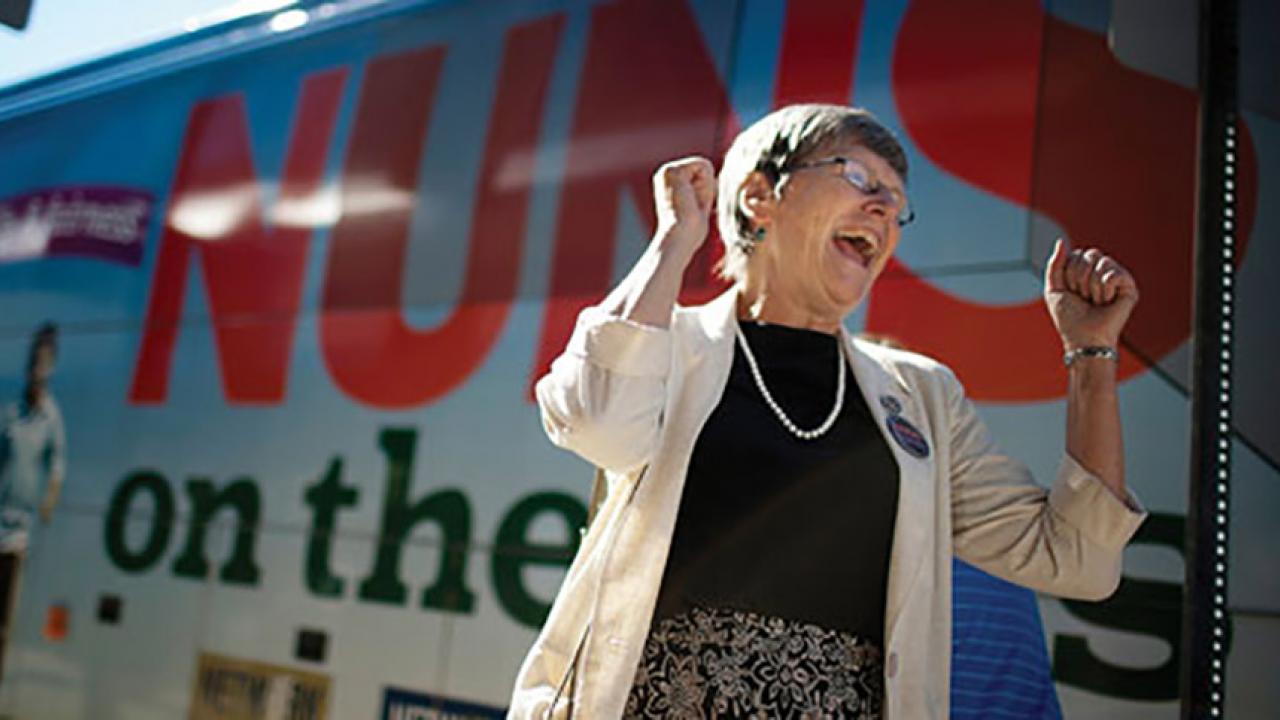 Sister Simone Campbell in front of a bus