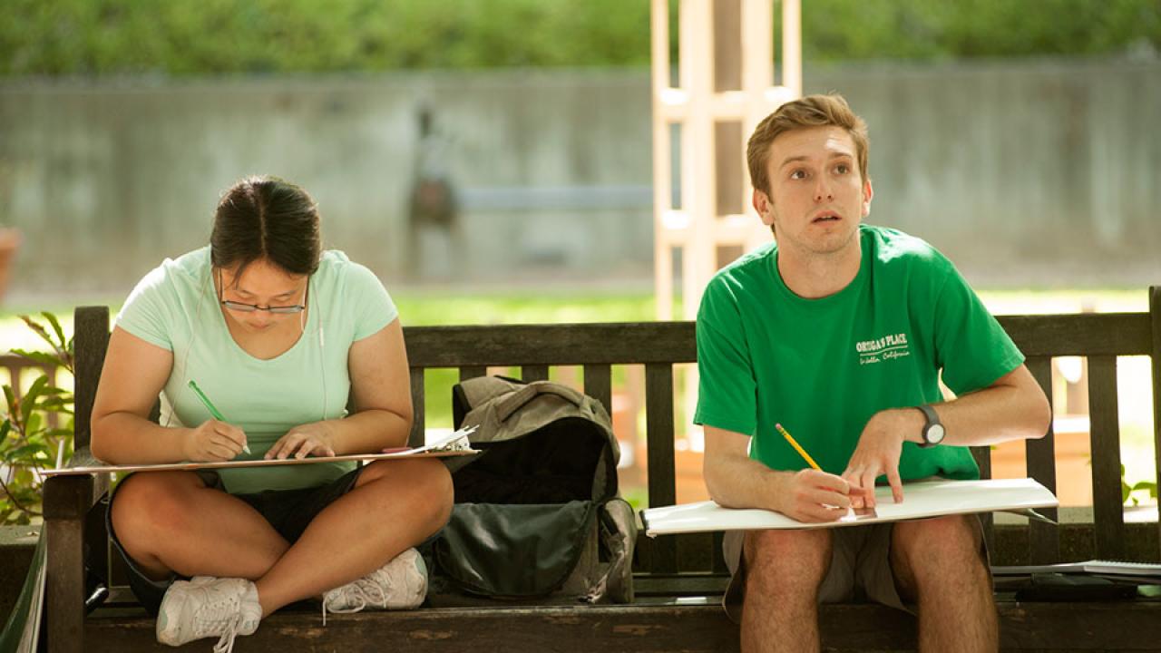 Two students draw outside in the summer