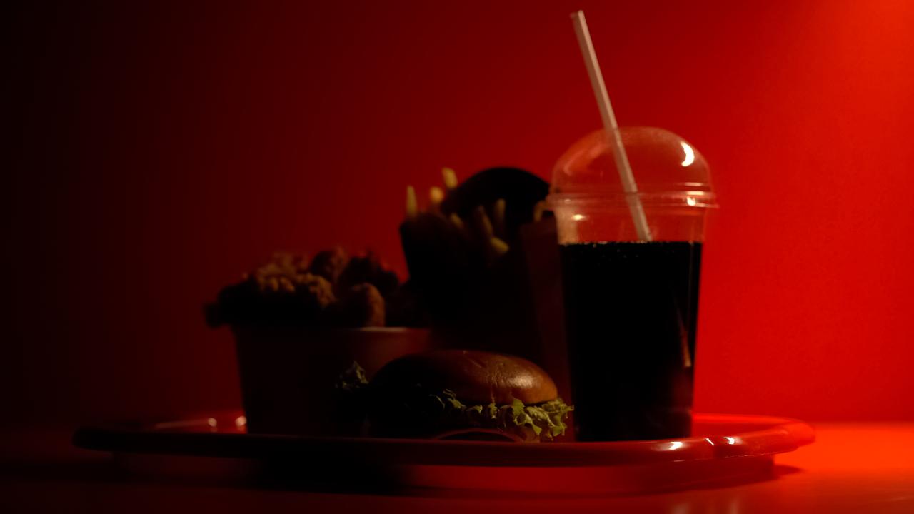 Beverage in plastic up with dark red background. 