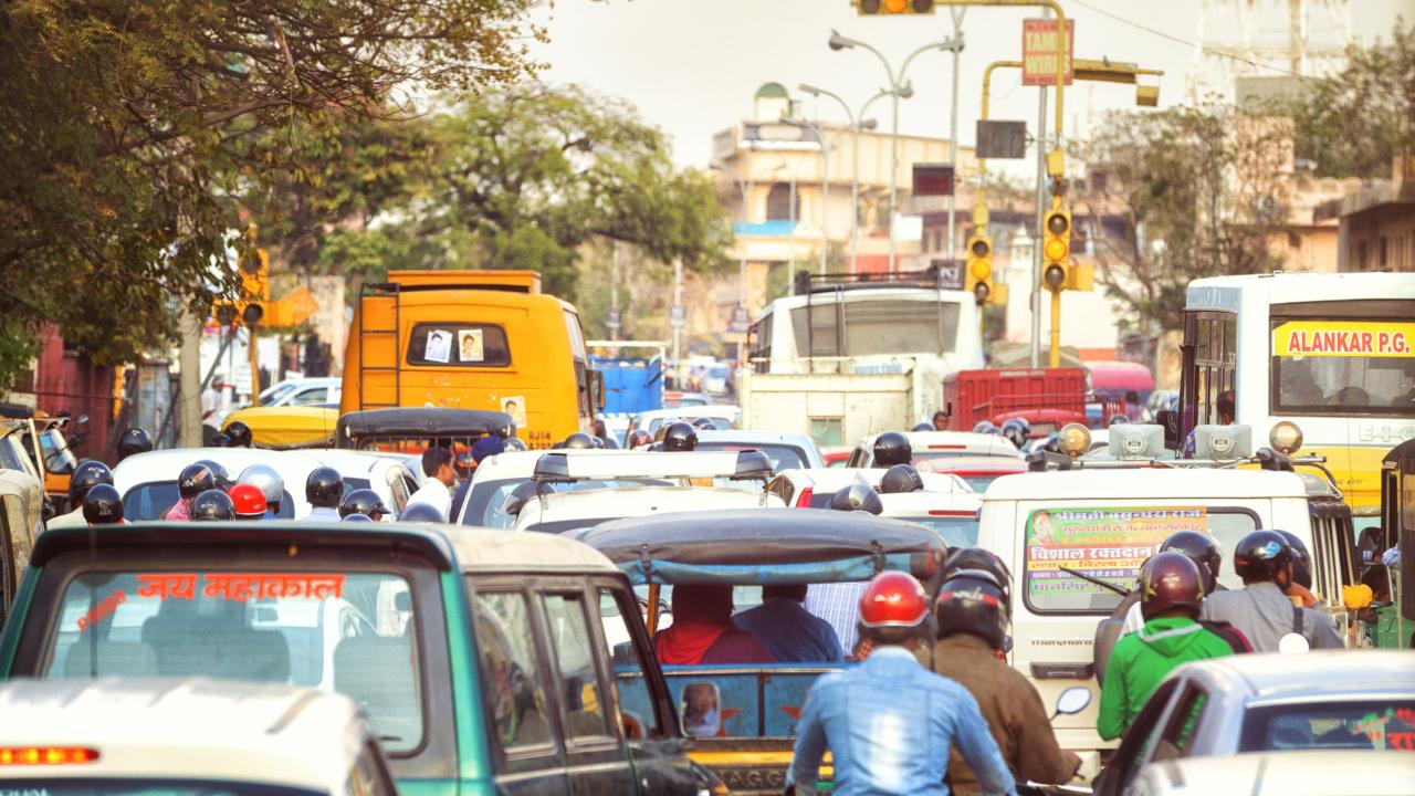 Buses, cars, and motorcyles congest a busy street in Jaipur, India