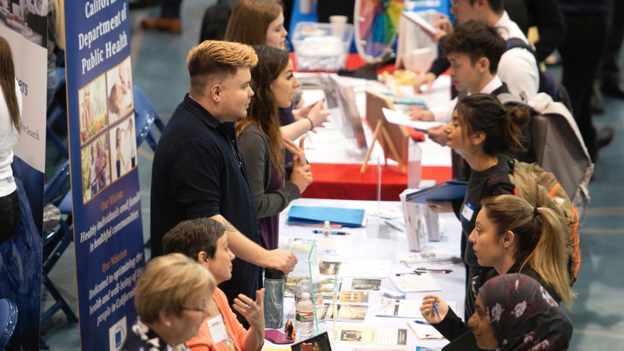 Students talk with prospective employers at a career fair in 2019.