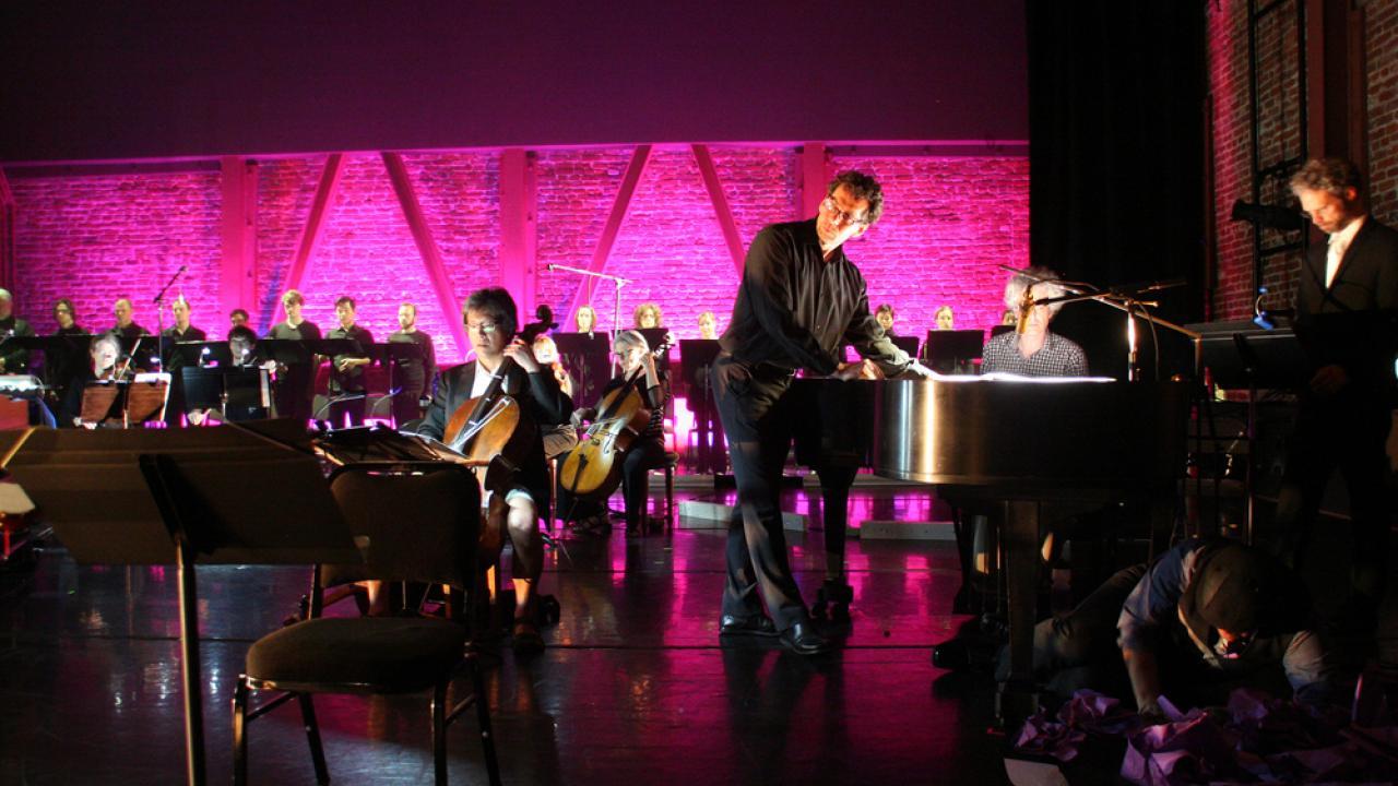 Composer on stage lighted in pink