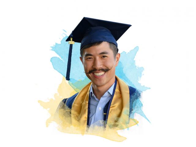 A smiling UC Davis graduate with an amazing mustache