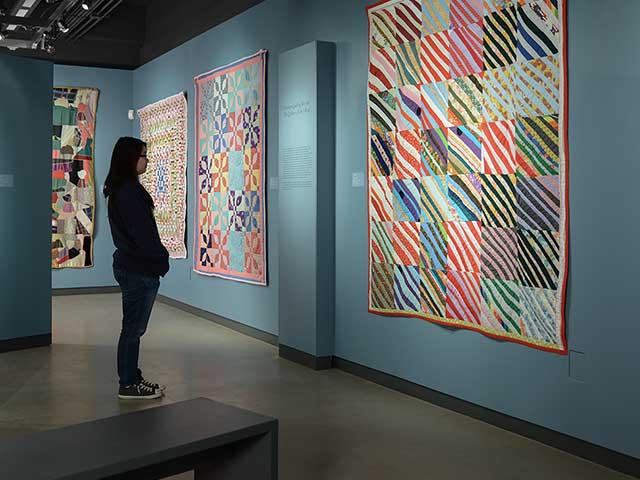 a student in the design museum looking at a large piece of art on a wall