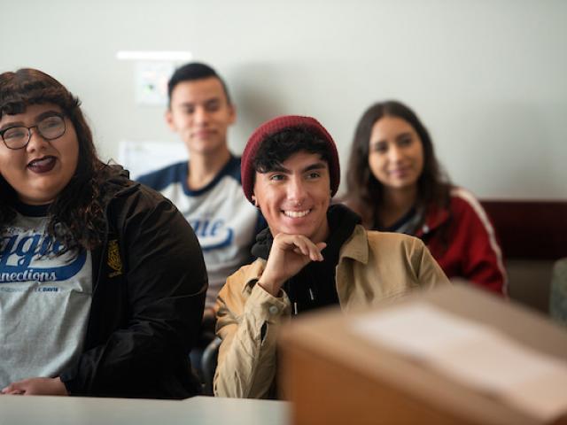 Students smile and listen in a lecture.