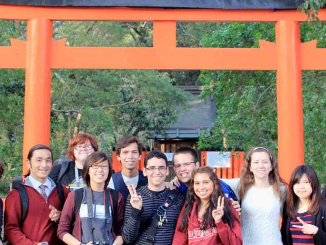 UC Davis students pose in front of a shinto shrine in japan.