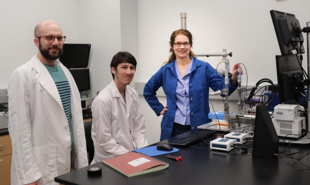 Three scientists in a lab setting. 