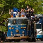 a vintage bus filled with students goes down the parade route durning Picnic Day