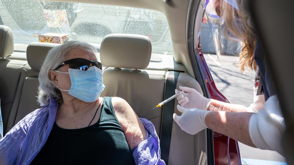 Woman sitting in car receives vaccine.