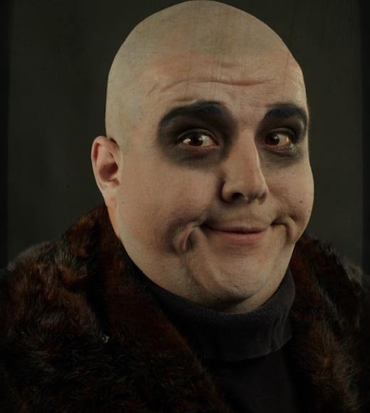 Character of Fester from Addams Family in white face and black wardrobe