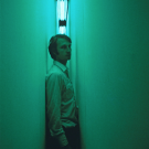 A man standing in Nauman's Blue and Yellor corridor.