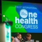 One Health Congress logo on a presentation screen behind event speakers.