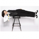 Paula Poundstone lying horizontally on a stool.