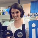 : English major Emilia Varshavsky Shapiro holds part of a LinkedIn sign