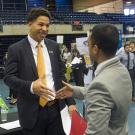 Job applicant shakes hands with a company representative at a UC Davis career fair
