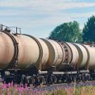A train carrying fuel travels through a prairie landscape
