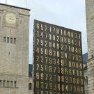 Photo: buildings in Poznan, Poland,  with monument covered in big brass numbers