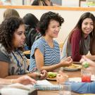 Female students talk over lunch in a dining commons