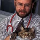 Photo: Man with stethoscope cuddling cat