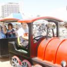 photo of employees riding on a mini train to the Health System TGFS festivities