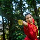 Woman executes sword movement in wushu martial arts