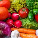 A variety of fruits and vegetables including tomatoes, onions, parsley, carrots, bell peppers