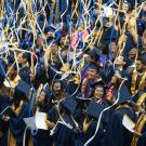 Streamers fall on graduates in caps and gowns.