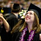 Female graduate in lei and mortarboard with thumb up