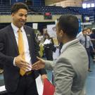 Two men in suits shaking hands at a career fair