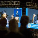 Two jumbo screens show a student rapping her commencement speech. (David Slipher/UC Davis)