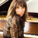 Photo: Lara Downes posed, on piano bench