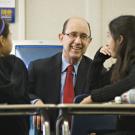 Photo: Dean Harold Levine chats with students in a classroom.