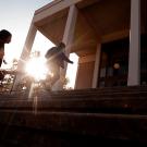 Two students climb the stairs in front of Rock Hall